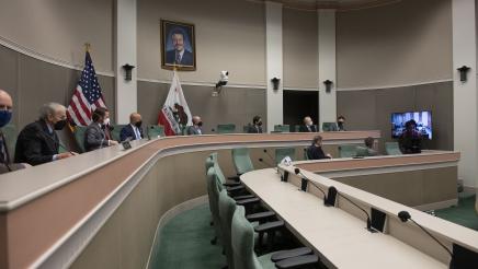 Committee members listening to remote testimony via TV