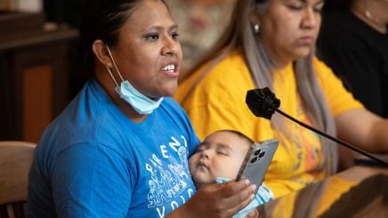 Witness providing testimony while holding sleeping baby