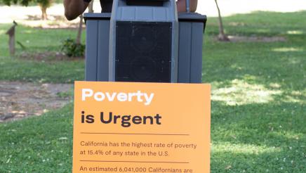 Stockton Mayor Michael Tubbs at podium, speaking with informational sign at front