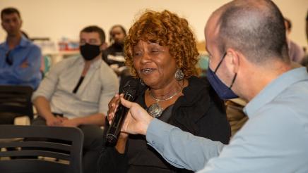 Staffer holding microphone as audience member speaks