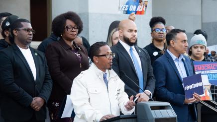 David Cruz, Board Member, Initiate Justice Action, at podium, speaking