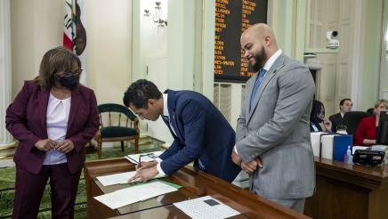 Speaker Rivas signing oath documents as Asm. Bryan looks on