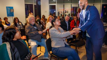 Asm. Bryan shaking hands with attendee and speaking with audience