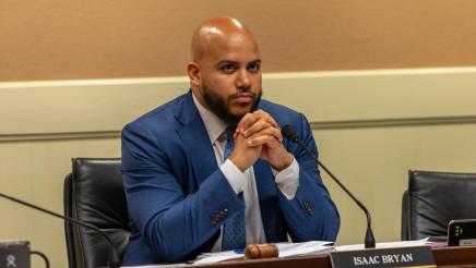 Asm. Bryan seated at desk, listening to testimony