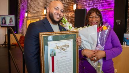 Asm. Bryan holding framed award, with awardee