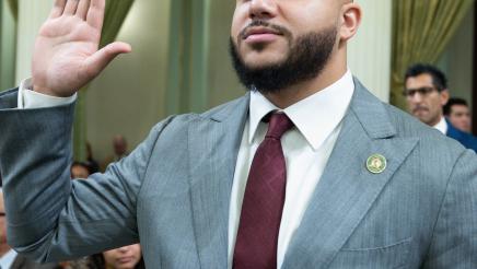 Asm. Bryan holding up his right hand in the Assembly Chambers