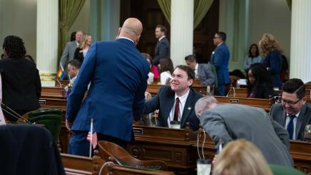 Asm. Bryan shaking hands with seated assemblymember