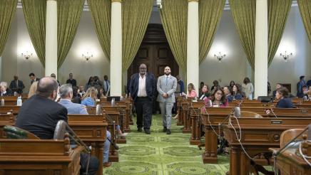 Asm. Bryan escorting honoree down aisle on the Assembly Floor