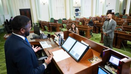 Asm. Bryan and child speaking with Assembly staffer