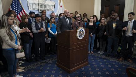 Asm. Bryan at podium, speaking, with multiple supporters in background