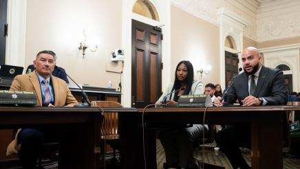 Asm. Bryan providing testimony as witnesses listen on