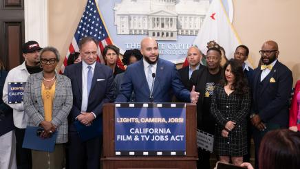Asm. Bryan at podium, speaking, with supporters at sides and in background