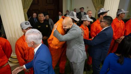 Asm. Bryan and other members embracing incarcerated firefighters